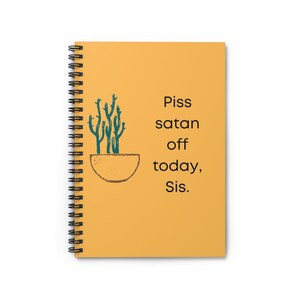 Puede incluir: Una libreta espiral amarilla con una ilustración de cactus verde y el texto "Piss satan off today, Sis."