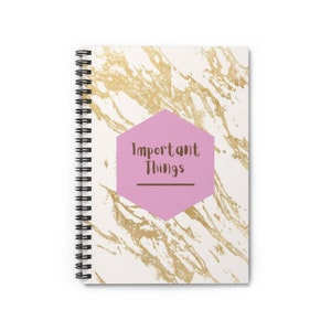 May include: A white spiral notebook with a gold marble pattern and a pink hexagon with the text "Important Things" in brown text.