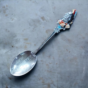 Peut inclure: Cuillère souvenir en argent avec un motif en émail coloré représentant un chef amérindien sur le manche et un aigle sur le bol. La cuillère est gravée des lettres "P.T."