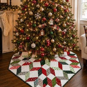 May include: A quilted Christmas tree skirt featuring a geometric star pattern in red, green, white, and grey fabrics. The fabric pieces are arranged in a repeating diamond and star motif with a dark green border trim around the circular edge.