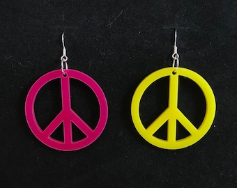 May include: A pair of peace sign earrings, one is yellow and the other is pink.
