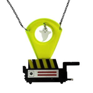 May include: A black and yellow Ghostbusters-themed necklace with a neon green ghost trap and a white ghost charm.