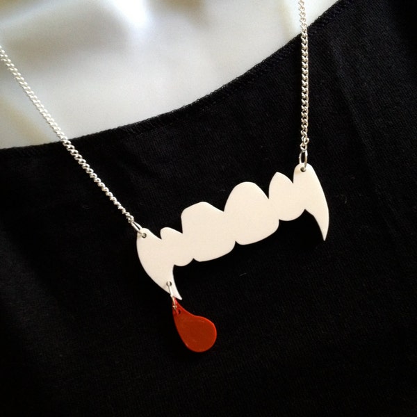 Des « crocs » de vampire et une goutte de sang. Collier