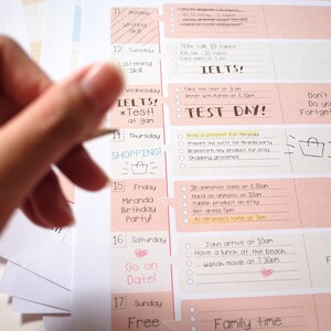 Puede incluir: Un planificador semanal rosa y blanco con una mano sosteniendo un bol&iacute;grafo sobre la secci&oacute;n del mi&eacute;rcoles. La secci&oacute;n del mi&eacute;rcoles tiene el texto "IELTS! *Test!* a las 9 am" escrito con un marcador negro. El planificador tiene una lista de actividades diarias para cada d&iacute;a de la semana.