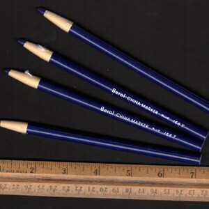 Peut inclure: Quatre marqueurs Berol China Marker bleus avec inscription blanche. Les marqueurs sont étiquetés "Berol China Marker Blue 168 T".