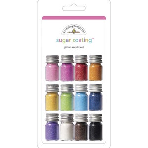 May include: A set of 12 small glass jars filled with different colored glitter. The jars are labeled "sugar coating" and "glitter assortment".