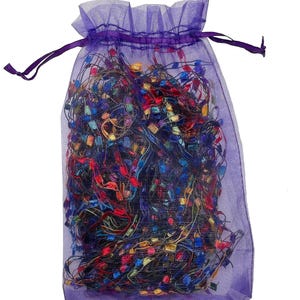 May include: A purple mesh bag filled with colorful, glittery ribbon scraps.