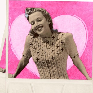 May include: A vintage-style photograph featuring a woman smiling, set against a pink heart backdrop. She wears a beige, button-down sweater with a cross pattern. The image has a retro aesthetic, reminiscent of old photographs.