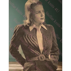 Op de afbeelding: Vintage afbeelding van een vrouw die een donkergrijze gebreide cardigan draagt met een kabelgebreid ontwerp. De cardigan is in de taille getailleerd met een bijpassende riem en een ronde gesp. De tekst "Stellar knits 4U" is zichtbaar.