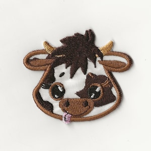 Può includere: Toppa ricamata di una mucca marrone e bianca con la lingua rosa che sporge. La mucca ha gli occhi grandi e un'espressione amichevole.
