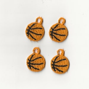 Könnte beinhalten: Vier orangefarbene und schwarze Basketball-Anhänger mit einer Schlaufe zum Aufhängen.