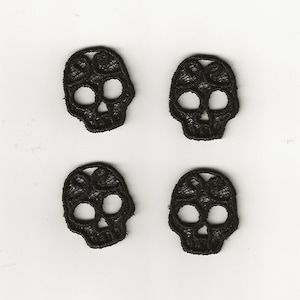 May include: Four black embroidered skull appliques. Each skull is approximately 2.5 cm in size.
