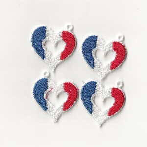 May include: Four small white heart-shaped charms with a red, white, and blue design. The charms are embroidered with the colors of the French flag.