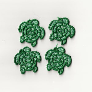 May include: Four green embroidered turtle appliques. Each turtle is about 1 inch in size.