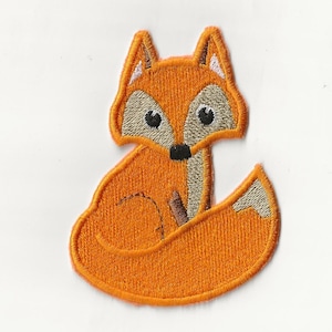 Peut inclure: Patch thermocollant brodé orange représentant un renard de dessin animé assis, la queue enroulée autour de son corps. Le renard a des yeux noirs, un nez noir et des oreilles intérieures blanches.