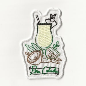 Pode incluir: Etiqueta bordada termocolante com um contorno branco de um copo de cocktail com um coco e um ananás verdes e castanhos, um canudo verde e uma faixa verde com o texto "Pina Colada".