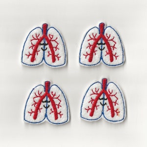 Könnte beinhalten: Vier weiße Filzpatches mit roter und blauer Stickerei, die eine menschliche Lunge mit Bronchien darstellen.