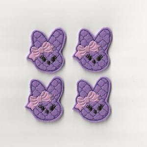 May include: Four purple felt bunny appliques with pink bows and black eyes.