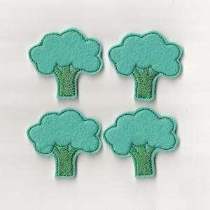 May include: Four felt green trees with brown trunks. The trees are simple and cartoon-like.