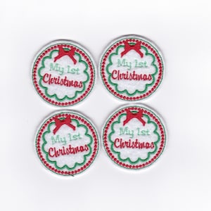 Puede incluir: Cuatro parches circulares bordados con "My 1st Christmas". Cada parche tiene un borde festoneado blanco, un lazo rojo y un borde verde con detalles rojos en forma de cuentas. Tema navideño.