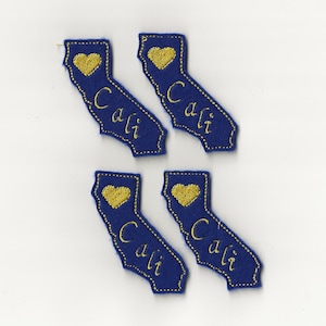 Puede incluir: Cuatro parches de fieltro azul con el contorno del estado de California, con un corazón dorado y la palabra "Cali" bordada en oro.