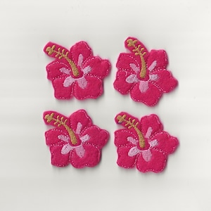 May include: Four pink felt hibiscus flower appliques with gold embroidered centers.
