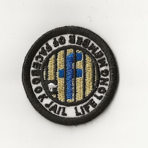 May include: Black and white embroidered patch with gold and blue accents. The patch is round and features the text "Life Long Journey to Freedom From Jail".