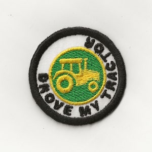 May include: An embroidered patch in black and white with a green and yellow tractor in the centre. The text around the tractor reads "I love my tractor".
