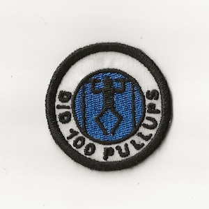 May include: A black and white embroidered patch with a blue circle in the center. The circle has a stick figure doing a pull-up. The text around the circle reads "Did 100 Pull-ups".