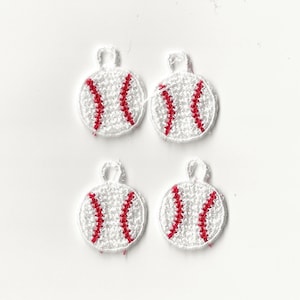 Könnte beinhalten: Vier weiße Baseball-Anhänger mit roten Nähten. Die Anhänger sind klein und haben eine Schlaufe oben zum Aufhängen.
