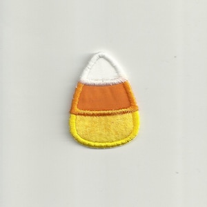 May include: A felt candy corn applique with white, orange, and yellow sections. The applique has a yellow outline.