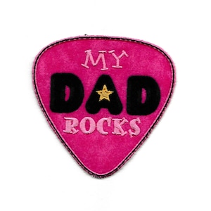 May include: Pink guitar pick shaped patch with black embroidered text that reads "My Dad Rocks" and a gold star.