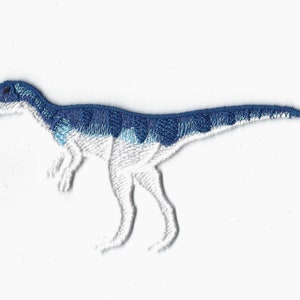 May include: Embroidered patch of a blue and white dinosaur. The dinosaur is standing on all fours and has a long tail.