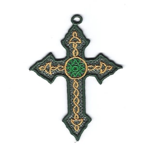 Può includere: Un ornamento a forma di croce celtica verde e oro con un intricato disegno di nodi. Il centro della croce presenta un cerchio verde con un disegno dorato.