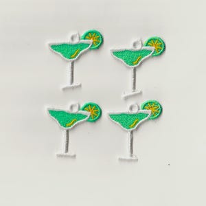 Puede incluir: Cuatro parches de hierro bordados de color verde y blanco de vasos de margarita con gajos de lima.