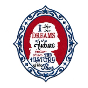 May include: A red, white, and blue embroidered patch with a silhouette of a woman's head in a blue oval frame. The text reads "I like the DREAMS of the future better than THE HISTORY of the Past".