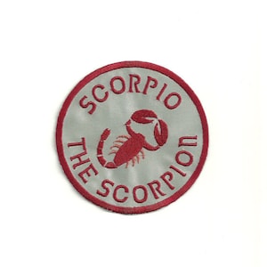 May include: A red embroidered patch with a white background. The patch is circular and features a scorpion with the text "Scorpio The Scorpion" around the edge.