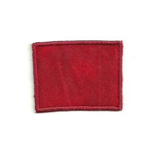 Op de afbeelding: Een rode stoffen patch met een gestikte rand.
