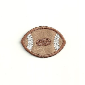 May include: A brown and white embroidered football patch.