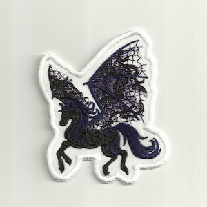 Puede incluir: Parche de hierro bordado en negro y morado de un caballo alado con un diseño de encaje.