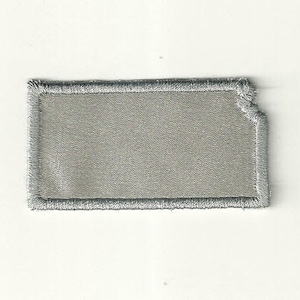 May include: A gray embroidered patch in the shape of the state of Kansas.