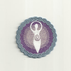 May include: Embroidered patch featuring a white figure with arms raised within a purple circle. The figure has a spiral design on the torso. The circle is bordered by a scalloped, gray trim. The patch is likely for clothing or accessories.