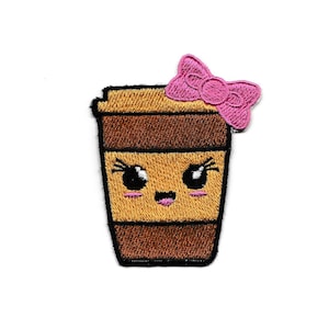 May include: Embroidered iron-on patch of a brown coffee cup with a pink bow on top. The cup has a cute cartoon face with big eyes and a smile.