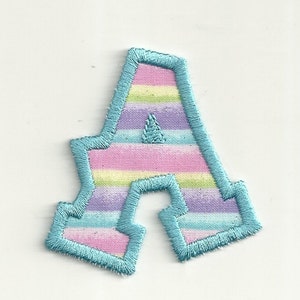 May include: A blue fabric letter A with a striped pattern in pink, purple, blue, and green.