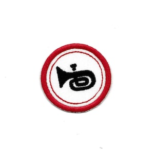 May include: A red and white embroidered patch with a black trumpet in the center.