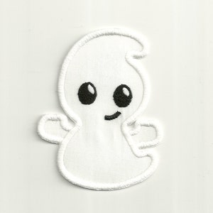 Puede incluir: Fantasma blanco bordado con ojos negros y una boca sonriente. El fantasma tiene dos pequeños brazos extendidos.