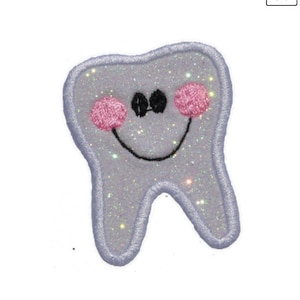 May include: A white sparkly tooth with a smiling face and pink cheeks. The tooth is embroidered with black thread.