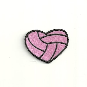 Può includere: Cuore rosa a forma di pallavolo con cuciture nere.