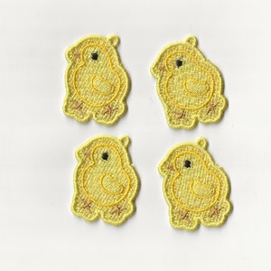 Puede incluir: Cuatro parches bordados de pollitos amarillos. Cada parche presenta un pollito con un ojo negro, un cuerpo amarillo y patas marrones. Los pollitos están delineados con hilo amarillo, sobre un fondo blanco.