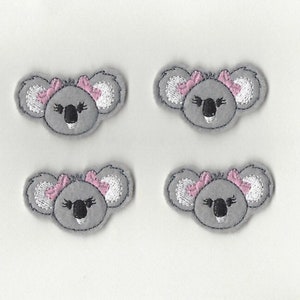 May include: Four gray felt koala bear appliques with pink bows. Each applique has embroidered black eyes and a nose.